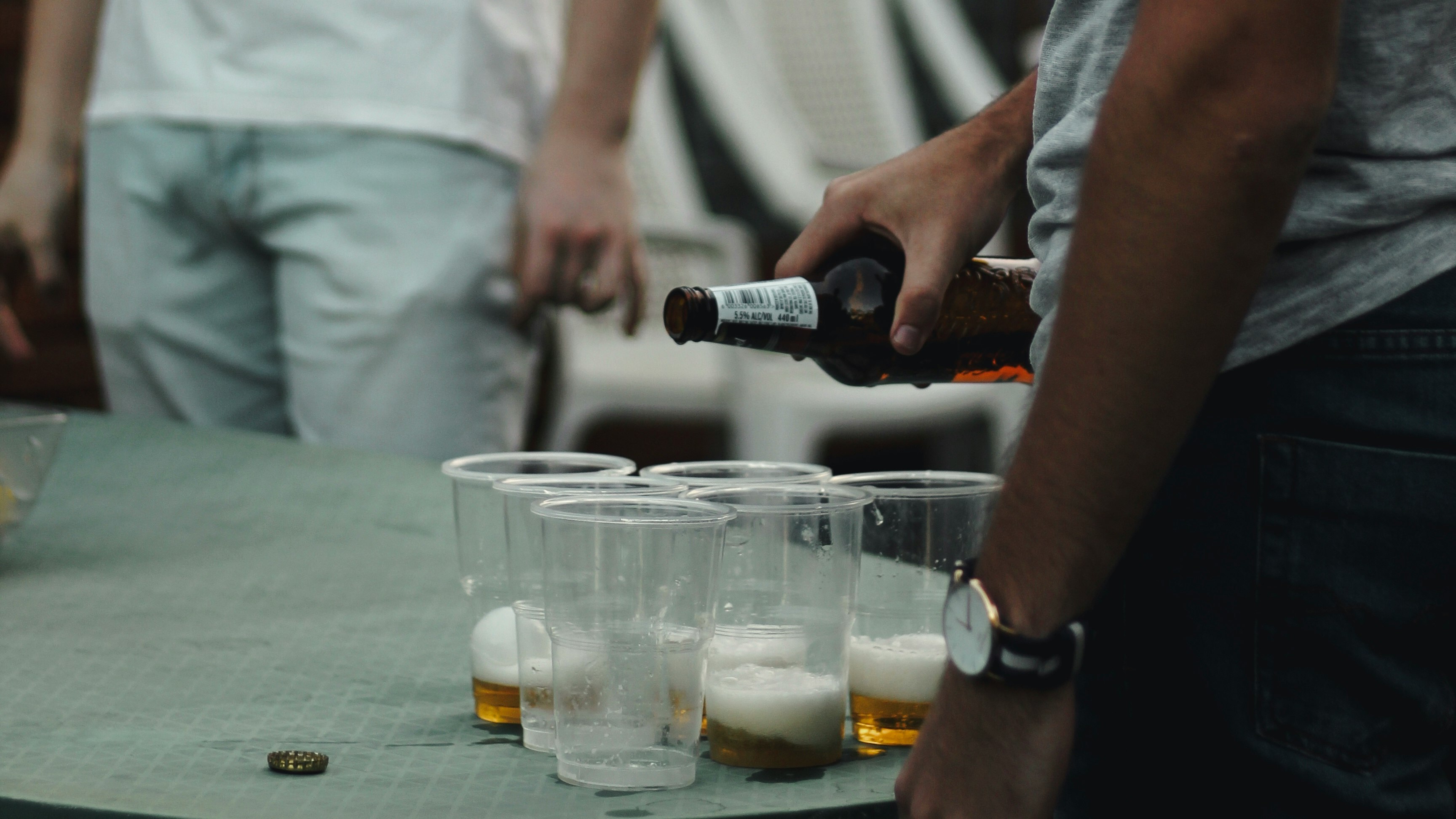 person pouring beer on clear glass mug